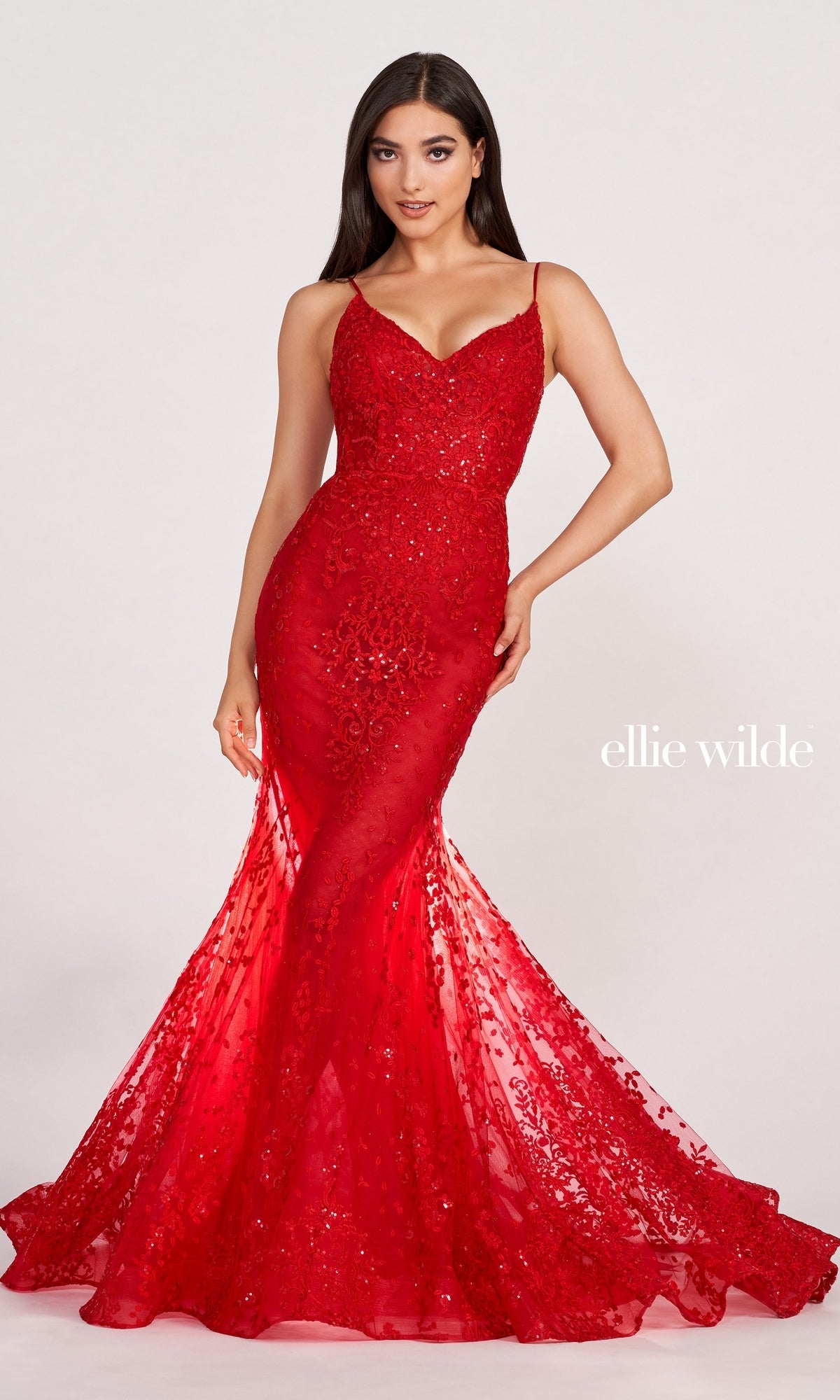 A woman models the Sequin-Lace Open-Back Long Mermaid Prom Dress, featuring thin straps, a corset back, and fitted sequin-lace fabric with a flared hem. She stands against a plain, light-colored background.